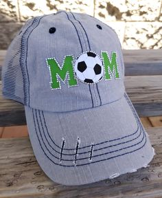 Mom Bling Trucker Cap, Soccer Mom Women's Trucker Hat, Distressed Soccer Hat, Bling Soccer Hat Many hat colors to choose from, you choose team colors and personalization for hat. This design can be done for any sport! Listing pictures are of a slightly distressed grey denim washed trucker cap with light grey stitching and light grey mesh back and adjustable strap with pony tail opening. MOM is on front in green with a rhinestone soccer ball YOU CAN ADD ADDITIONAL NAME or NUMBER PERSONALIZATION- Gray Distressed Hat, One Size Fits Most, Trucker Baseball Cap With Brim, Trucker Style Brimmed Baseball Cap, One Size Fits Most Trucker Baseball Cap, Distressed Green Cap Hat, Green Distressed Cap, Adjustable Distressed Trucker Hat For Baseball Season, Casual Customizable Trucker Visor Hat, Distressed Adjustable Gray Baseball Cap