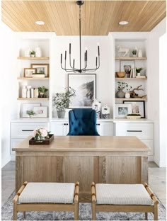 a dining room table with two chairs and a chandelier hanging from the ceiling