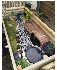 a small garden with rocks and plants in the center, along with a wooden bench