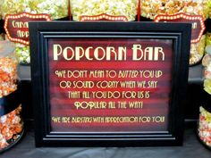 there is a sign on the table that says popcorn bar, we don't want to butter you up