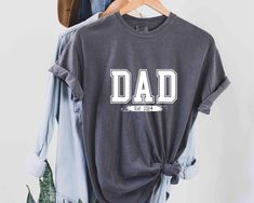 Dad Est 2024 Tshirt, New Dad Shirt, Personalized Dad Shirt, Custom Dad, Pregnancy Announcement for Dad, Gift for Dad, Father's Day Shirt HOW TO ORDER Please, check and review all photos Choose your size from the drop-down menu and add each shirt to your cart one at a time. Click add to cart. You can go back to add more product Click "Proceed to check out" When you check out, you can add a note to the seller for any request Youth, toddler unisex adults round neck shirts are available in all color Casual Father's Day Shirt With Screen Print, Casual Screen Print Shirt For Father's Day, Casual Shirt With Screen Print For Father's Day, Father's Day Casual Pre-shrunk Shirt, Family Matching Relaxed Fit T-shirt For Father's Day, Casual Shirt With Text Print For Father's Day, Casual Family T-shirt With Name Print, Casual Relaxed Fit Shirt For Family Events, Casual Crew Neck Tops For Father's Day