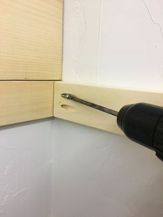 a screwdriver is attached to the side of a wall