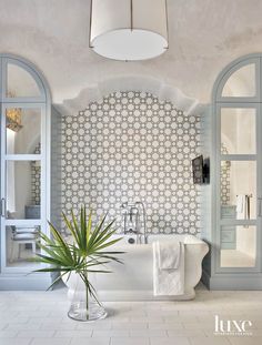 a bathroom with a bathtub, sink and potted plant