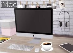 a computer monitor sitting on top of a desk next to a cup of coffee and tablet