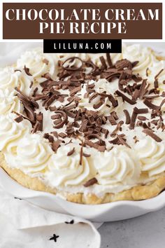 a chocolate cream pie with whipped cream and chocolate sprinkles on top in a white dish