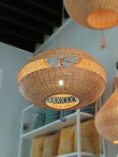 several wicker lamps hanging from the ceiling in a room with bookshelves and shelves