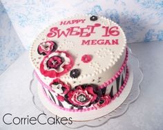 a decorated birthday cake with pink and black flowers