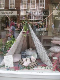 a window display with pillows and other items in the store's windowsills