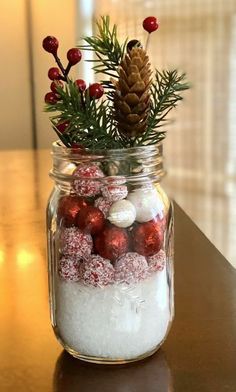 a glass jar filled with snow and christmas decorations