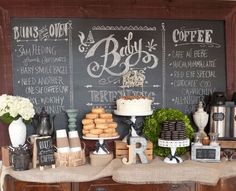 a buffet table with cakes, coffee cups and pastries on it in front of a chalkboard