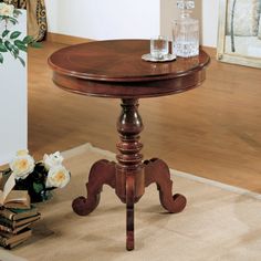 a wooden table sitting on top of a carpeted floor next to a vase filled with flowers