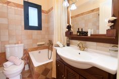 a bathroom with a sink, toilet and bathtub next to a mirror on the wall