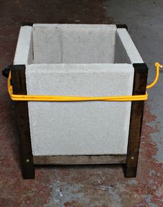 a large white container with yellow handles sitting on top of a floor