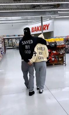 a man in a black and white sweatshirt is walking through a store with his back to the camera