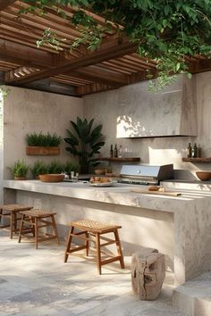 an outdoor kitchen with stone counter tops and stools under a pergolated roof