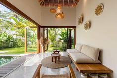 a living room filled with furniture next to a swimming pool