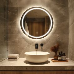 a bathroom sink with a round mirror above it