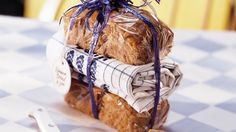 a loaf of bread wrapped in plastic sitting on top of a table next to a knife