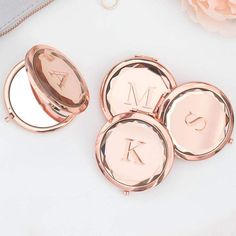 three personalized rose gold compacts with monogrammed initials on the front and back