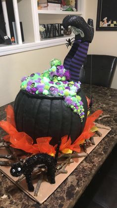 a decorated pumpkin sitting on top of a table next to a black cat and spider