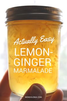 a hand holding a jar of lemon ginger marmalade with the words actually easy