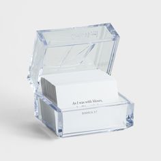 a clear glass business card holder with two cards in it's front and back