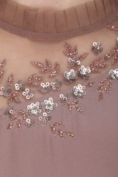 the back of a woman's dress with sequins and flowers on it