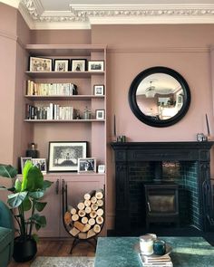 a living room filled with furniture and a fire place in front of a mirror on the wall