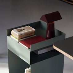 a small table with books and a lamp on it's side, in the shape of a cube