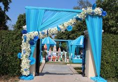 a blue and white wedding arch decorated with flowers