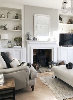 a living room filled with furniture and a flat screen tv mounted on the wall above a fire place