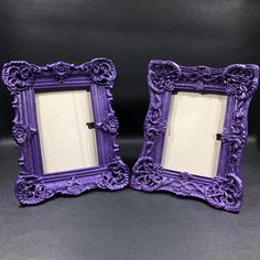 two purple frames sitting next to each other on a black surface with one holding a mirror