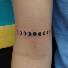 a person with a tattoo on their arm that has five phases of the moon in it