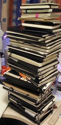 a stack of books sitting on top of a desk next to a computer keyboard and mouse