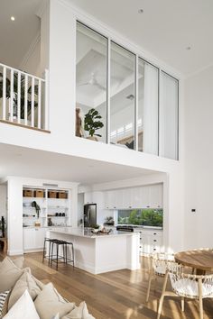 a living room filled with furniture next to a kitchen and dining room table on top of a hard wood floor