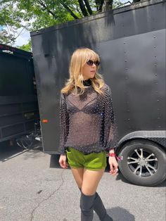 a woman in short shorts and boots standing next to a trailer