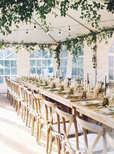 a long table with chairs and place settings