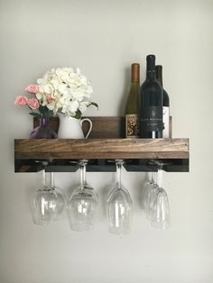 three wine glasses are hanging from a shelf