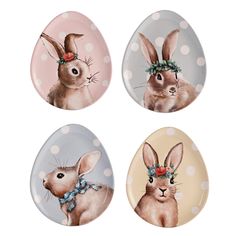 three plates with rabbits painted on them in different colors and designs, one has a bow around its head