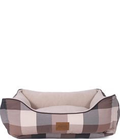 the dog bed is made from plaid fabric and has a brown leather tag on it