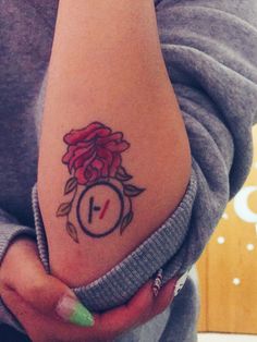 a woman's arm with a tattoo on it that has a clock and flowers