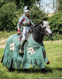 a man in armor riding on the back of a horse