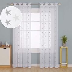 the curtains in this room are white and have silver stars on them, along with a plant