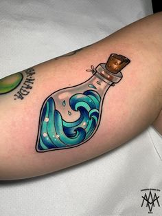 a bottle filled with water and waves on the side of a woman's arm