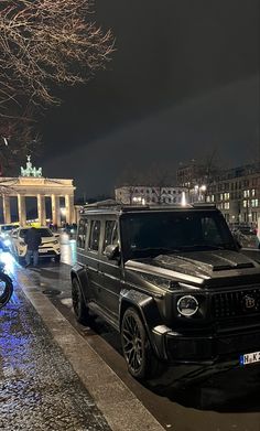 the cars are parked on the side of the road in front of some buildings at night