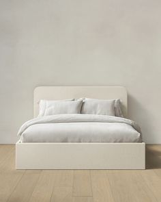 a white bed sitting on top of a wooden floor