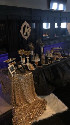 a table topped with lots of gold and black desserts covered in sequins