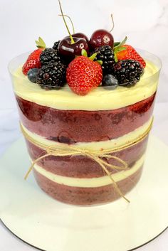 a layered cake with berries and cream on top