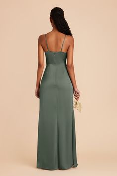 the back of a woman wearing a long green dress with spaghetti straps and low neckline