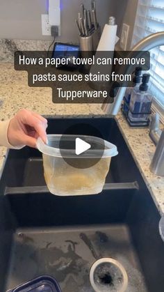 a person holding a plastic container over a sink